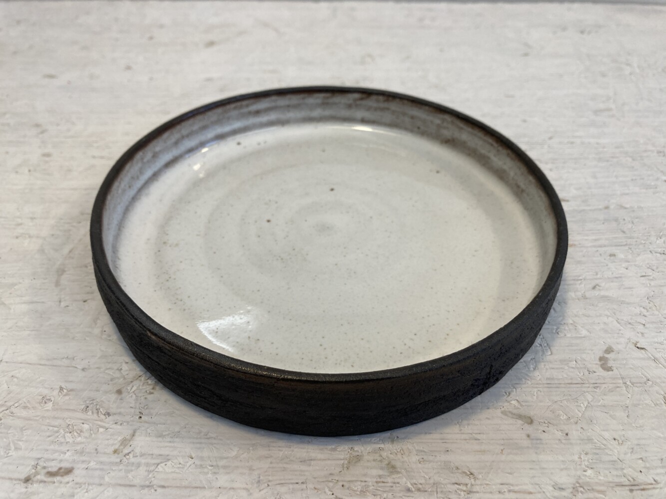 krožnik bel na črni glini 2 plate white on black clay small